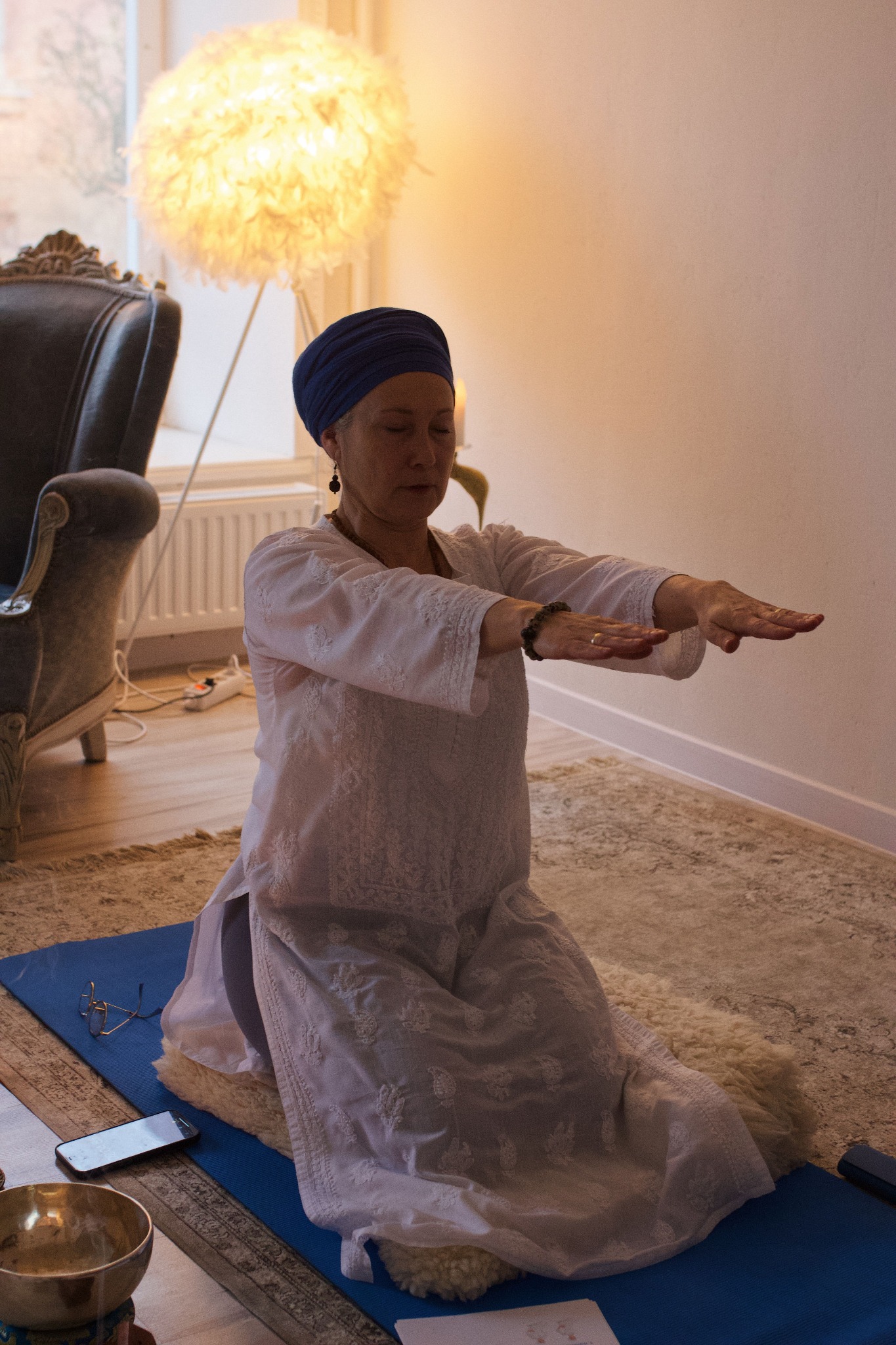 Linda zilā turbānā jogas praksē ar izstieptām rokām