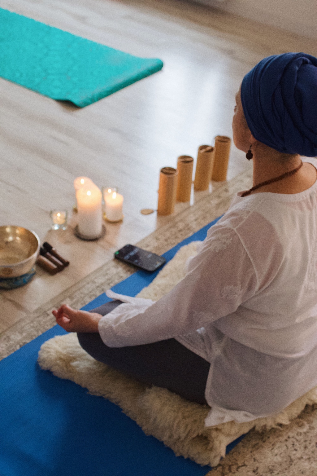 Linda zilā turbānā meditācijā pie svecēm