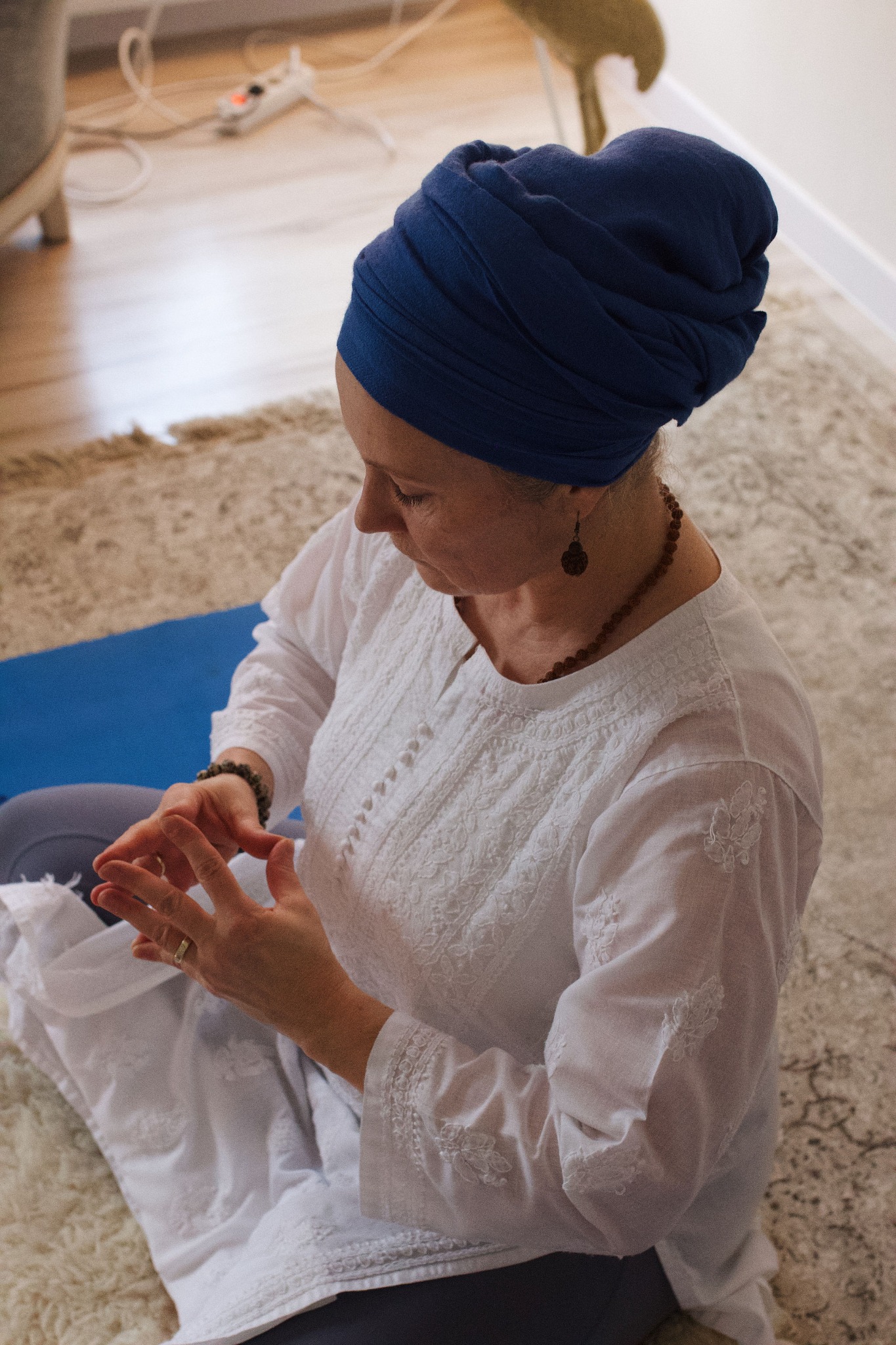 Linda zilā turbānā meditācijā ar roku mudru